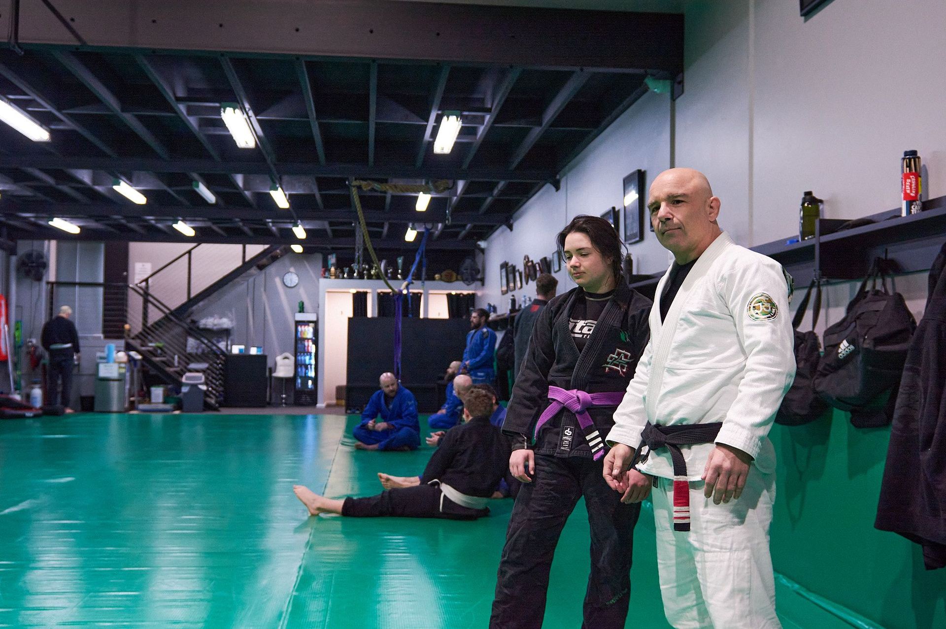 Jamie Murray coaching two beginners on the mat at Renegade
